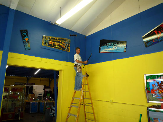 Bryan fixes some pinball cabinet sides to the walls
