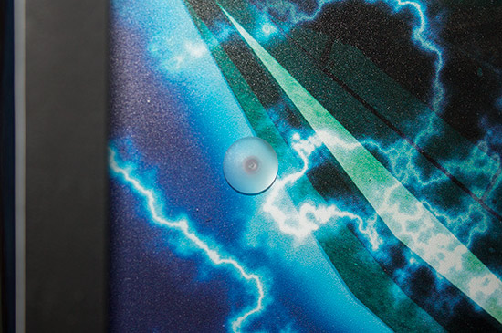 The plastic rivet attaching the translite to the clear plastic sheet 