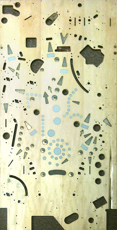 A whitewood playfield with insert cutouts