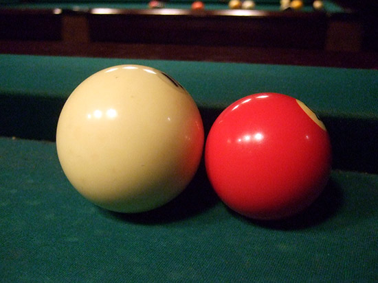 The larger Russian Pyramid ball compared to a regular pool ball
