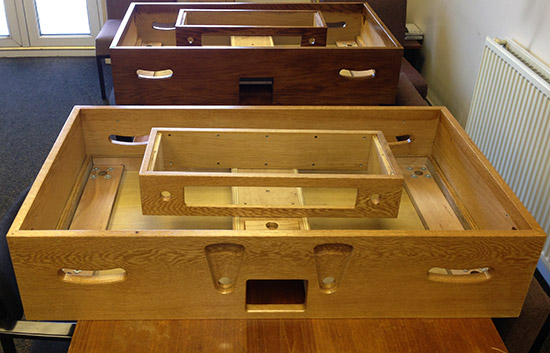 A varnished solid oak prototype cabinet (front) and one with both stain and varnish (back) 
