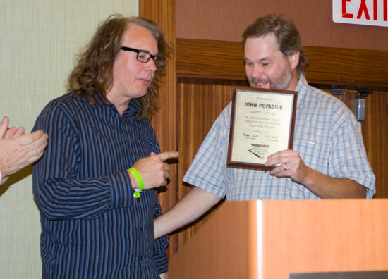John receives his plaque from Michael