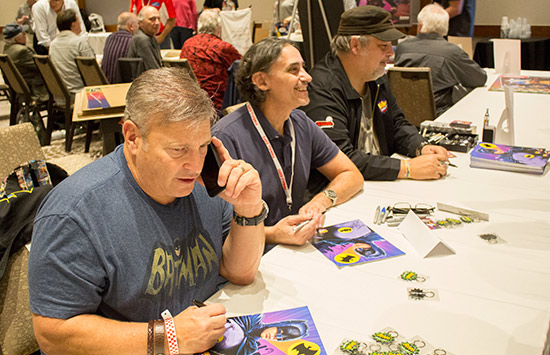 The Batman 66 crew from Kapow and Stern sign game flyers