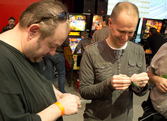 Dom Escott and Greg Mott race to be the first to spearate their name badge from the backing