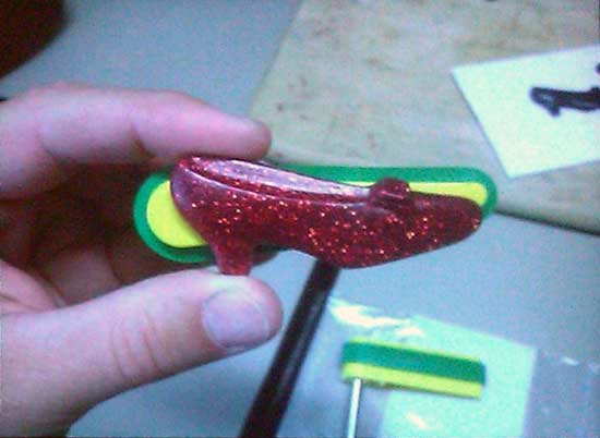 They've been playing around with red heeled shoes as toppers for the flippers. He mentioned that at some point in the game there will be some clicking of the "heels" as in the movie.
