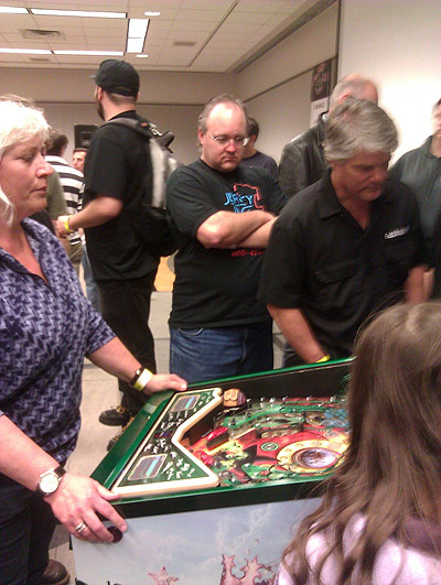 Keith looks on while people flip on the machine