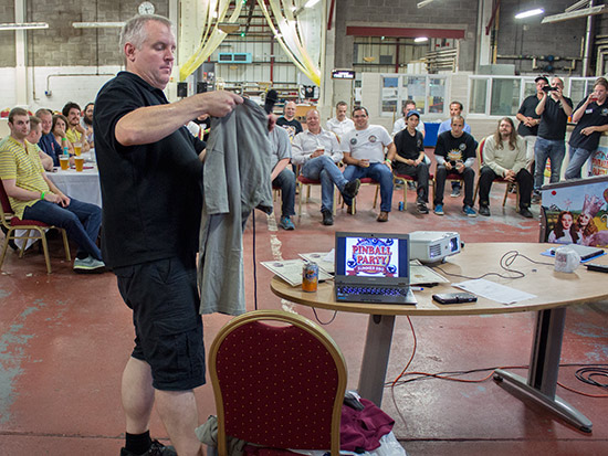 Andrew shows one of the T-shirts being auctioned