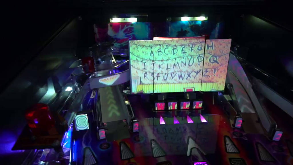 The projector beams artwork onto the movie screen, drop targets, standup targets, ramps and spinner