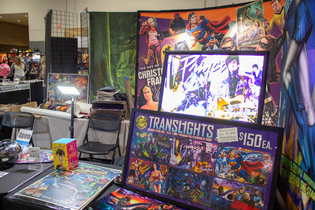 Popular pinball artist, Christopher Franchi, was busy signing posters on the American Pinball stand, but had a stand of his own selling his artworks
