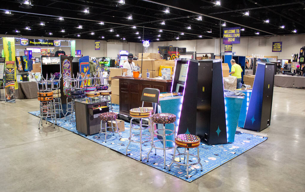 Across the hall, stands were coming together