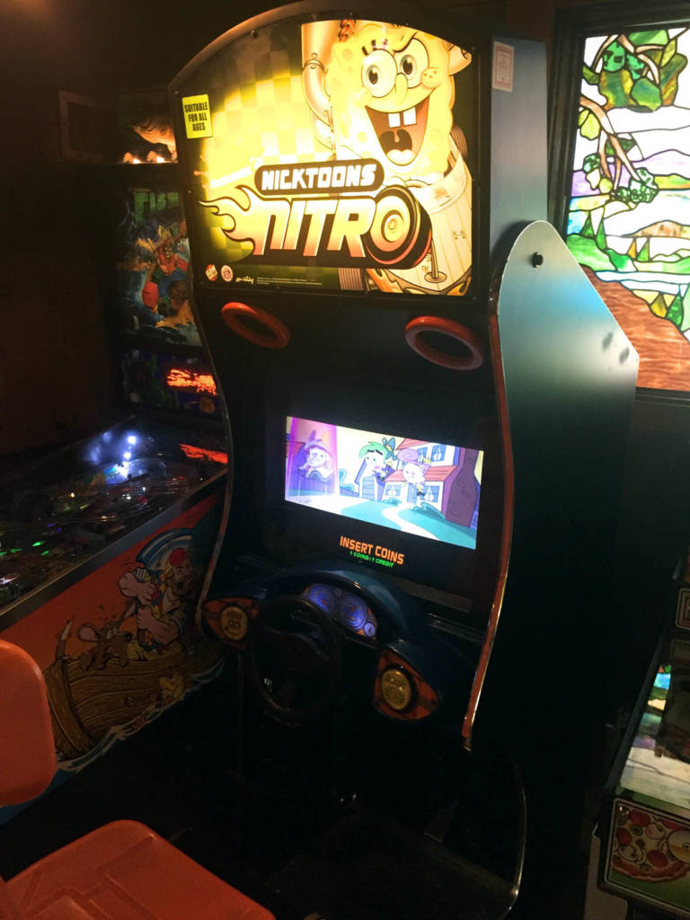 A kids' driving video game next to the pinball